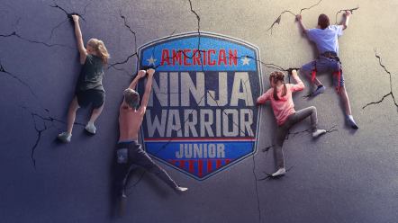 Four kids climbing a grey, cracked wall with a large logo in the middle.