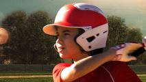 A close-up of a young boy wearing a baseball helmet.